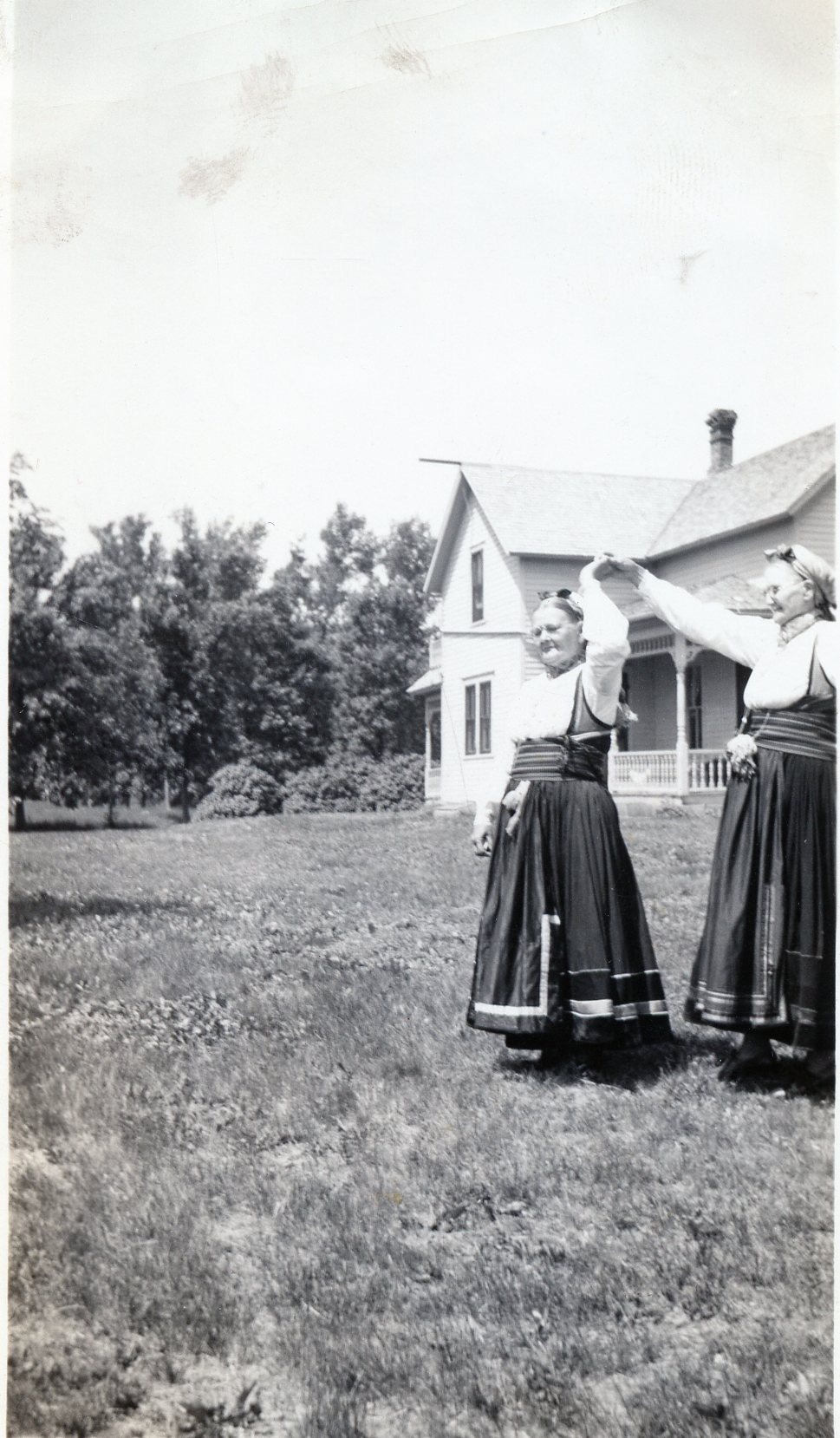 two women in bunad dancing, black and white