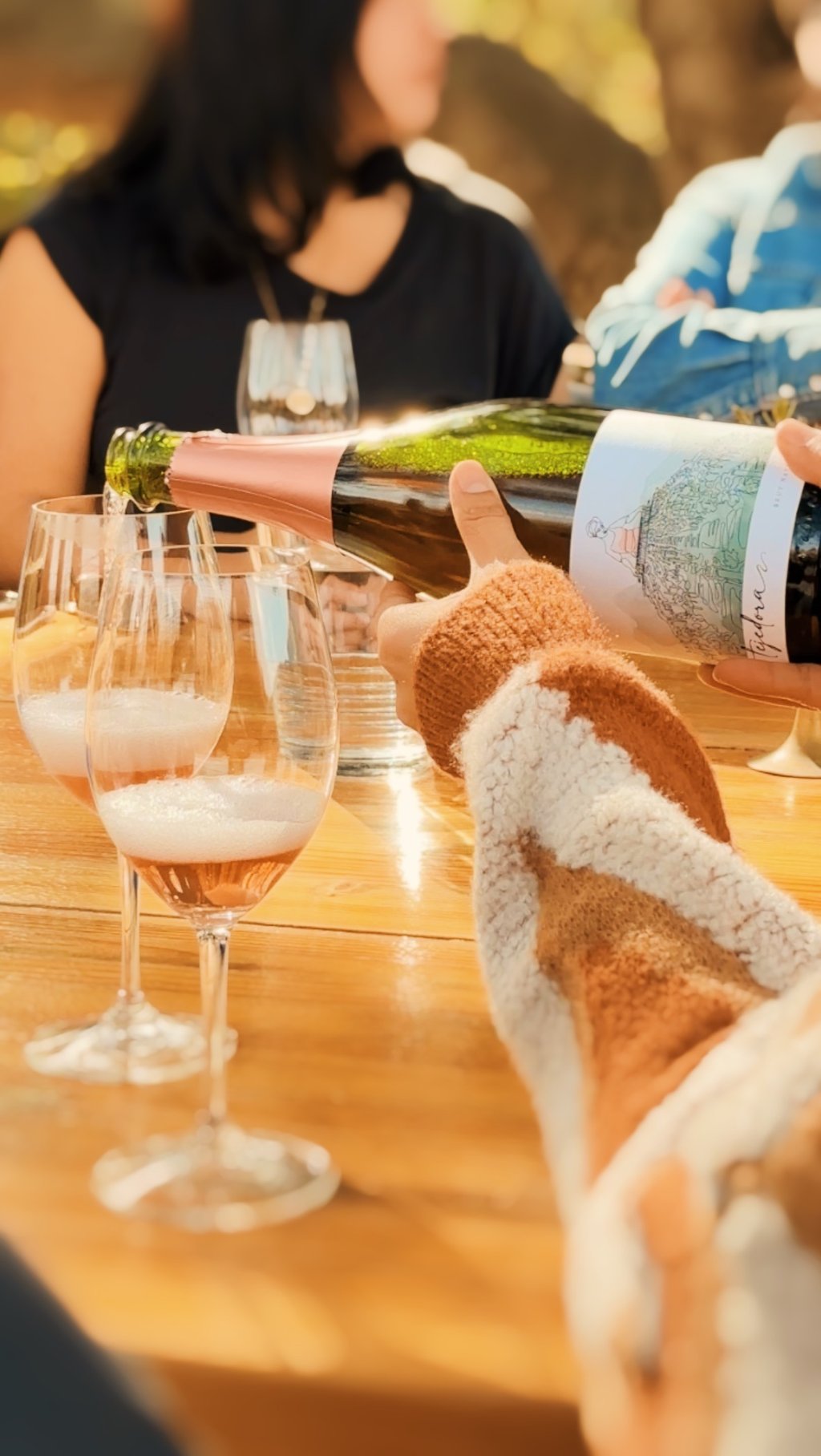 a person is pouring sparkling wine into a glass in a wine tasting at Mina penelope winery