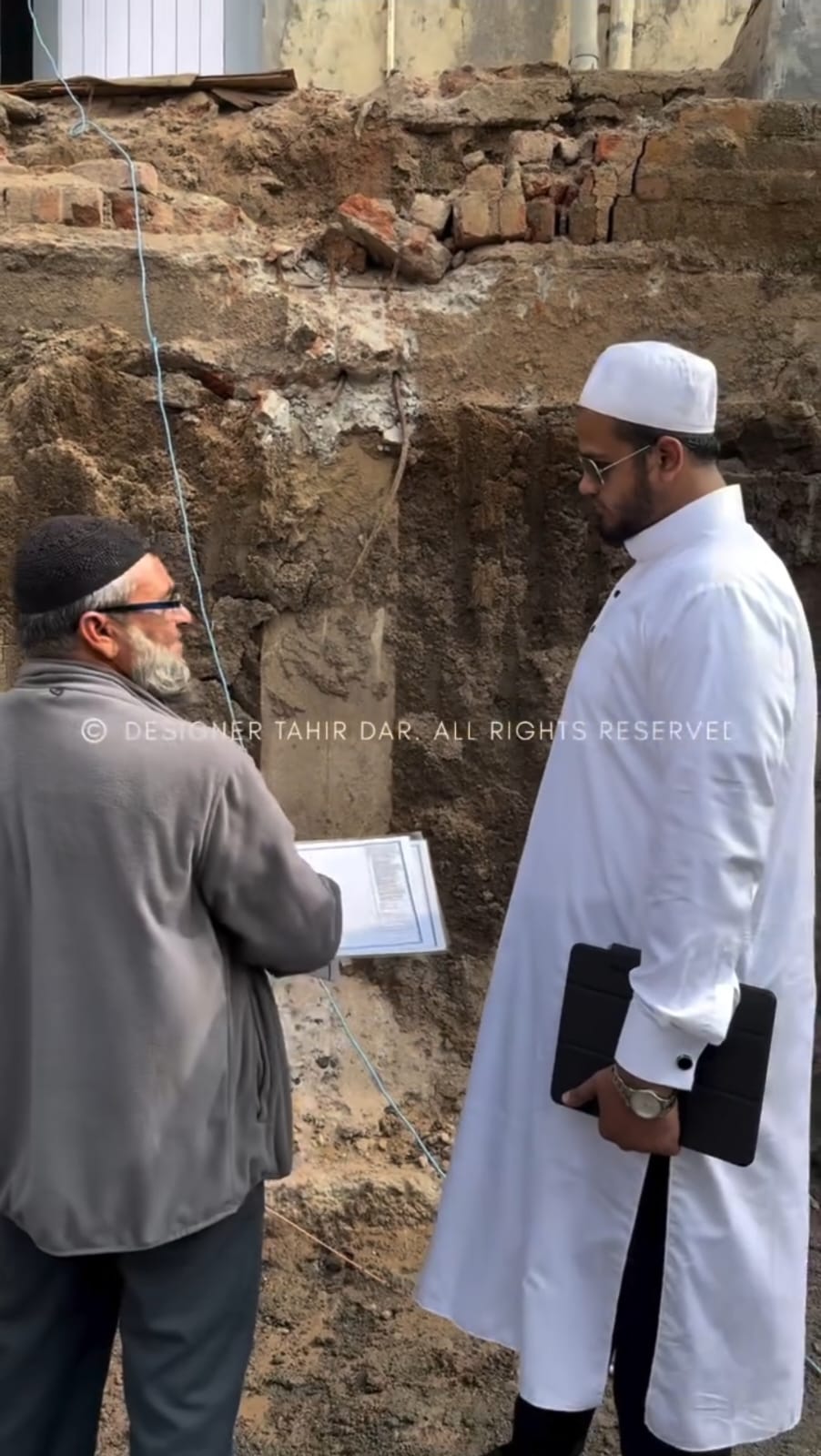 Engineer and architect in Hyderabad discussing construction plans with workers on-site, showcasing t