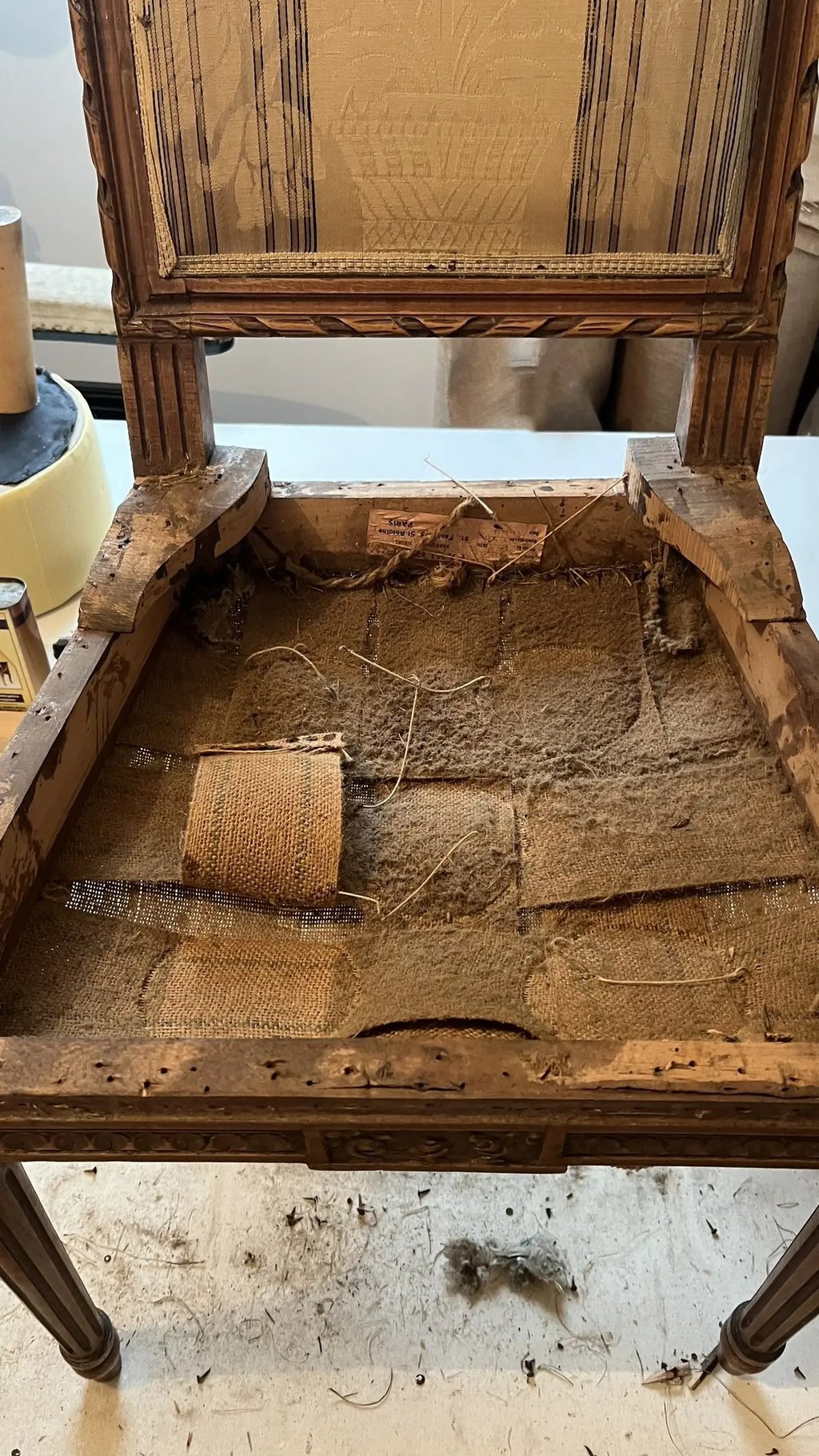 Chaise laissant à découvert de vieilles sangles poussiéreuses et abimées