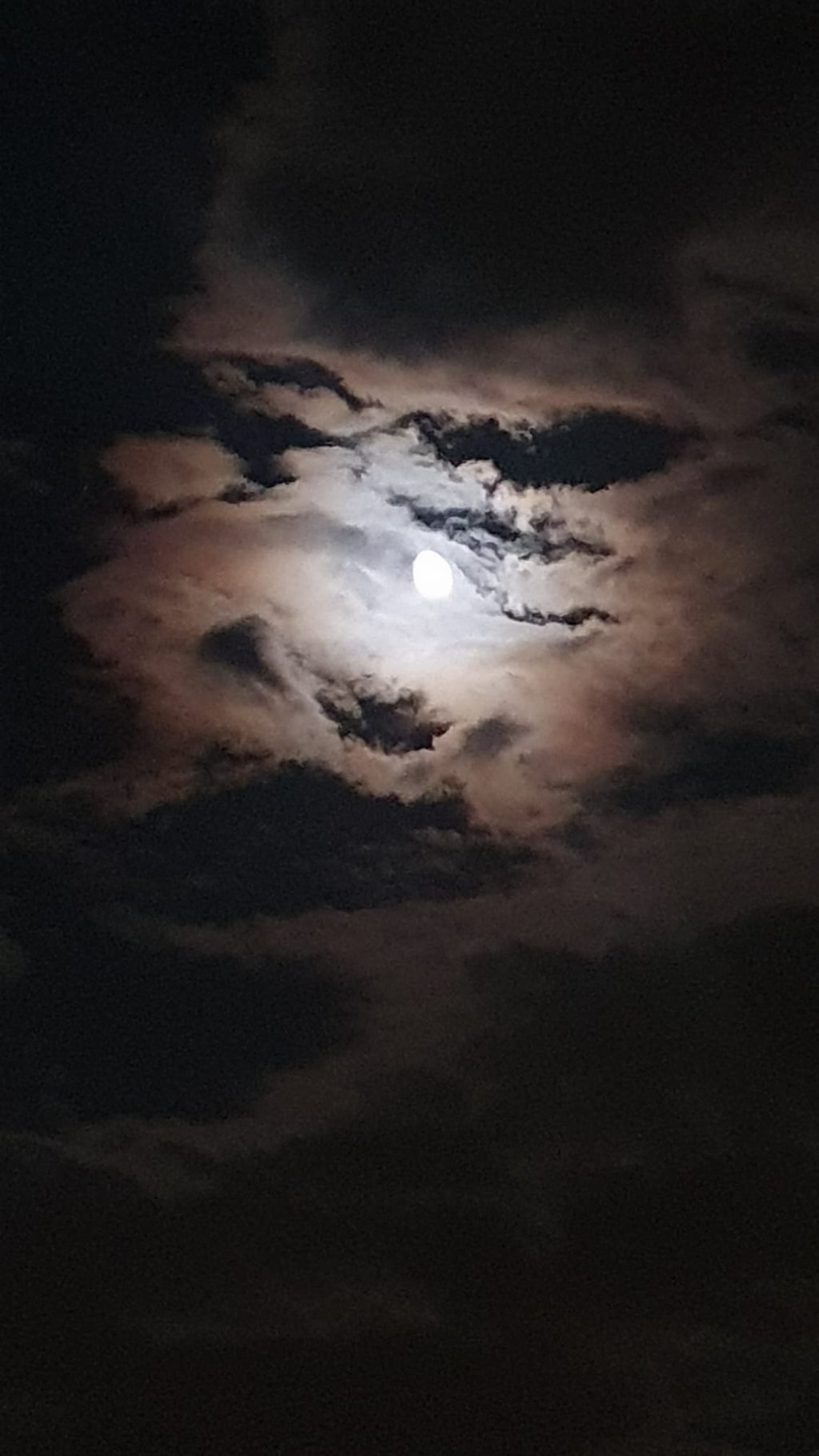 a full moon in the sky with clouds shot during night boat tour