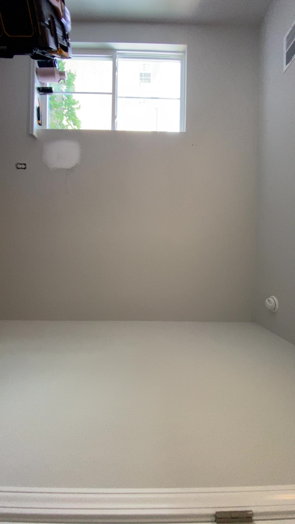 Old white walls with patched hole