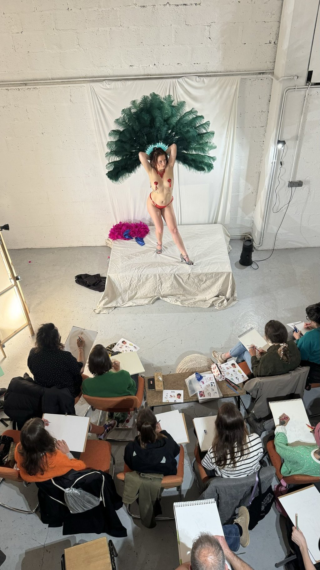 Atelier dessin modèle vivant. Femme modèle avec éventails en plumes.