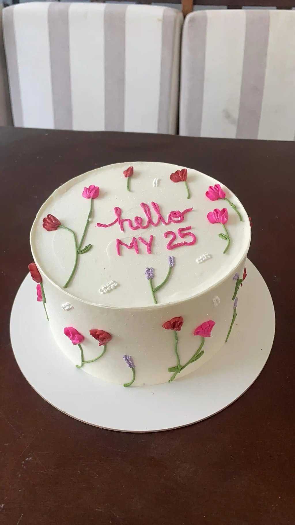 Bolo de aniversário decorado com flores coloridas, com a inscrição 'hello MY 25' em cima. Ideal para