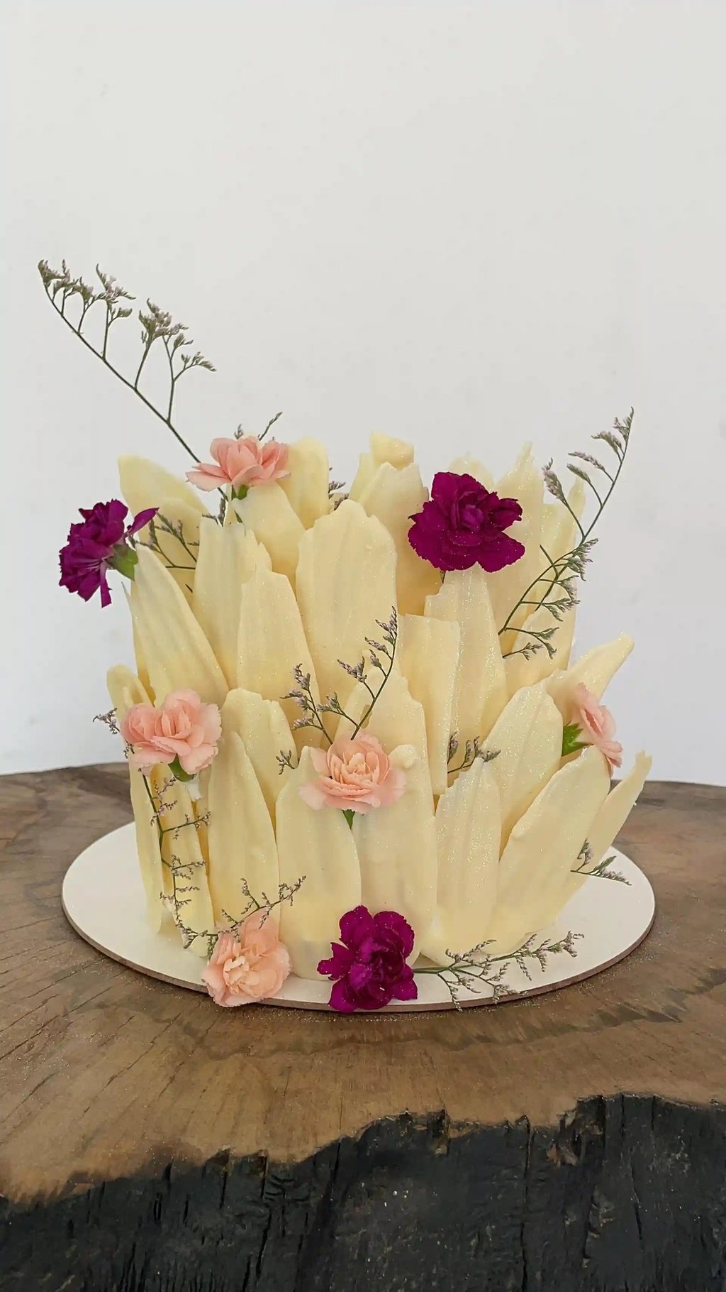 Bolo decorado com detalhes florais e texturas que imitam pétalas, ideal para festas e celebrações. D