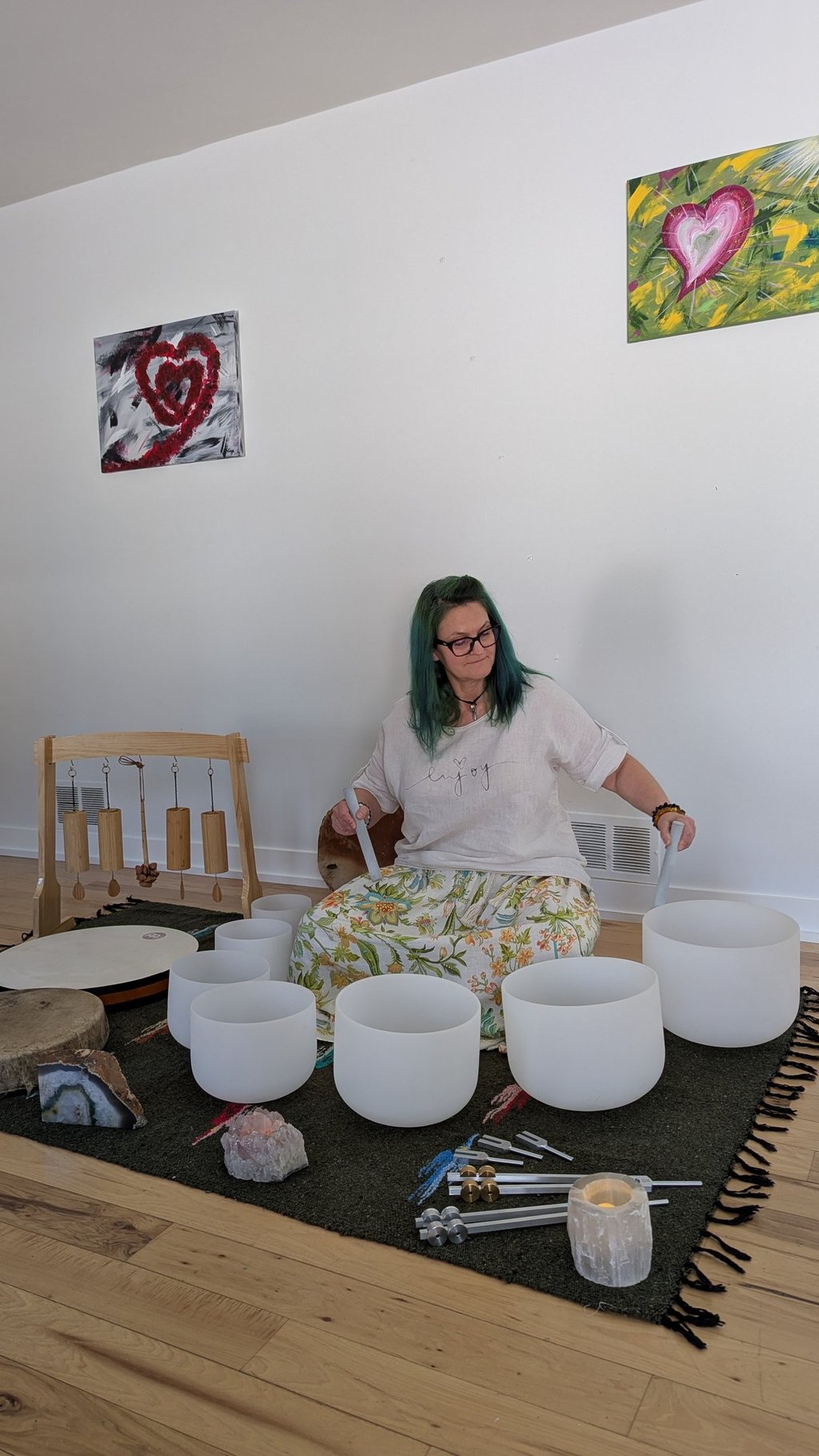 A woman playing on the sound bowls