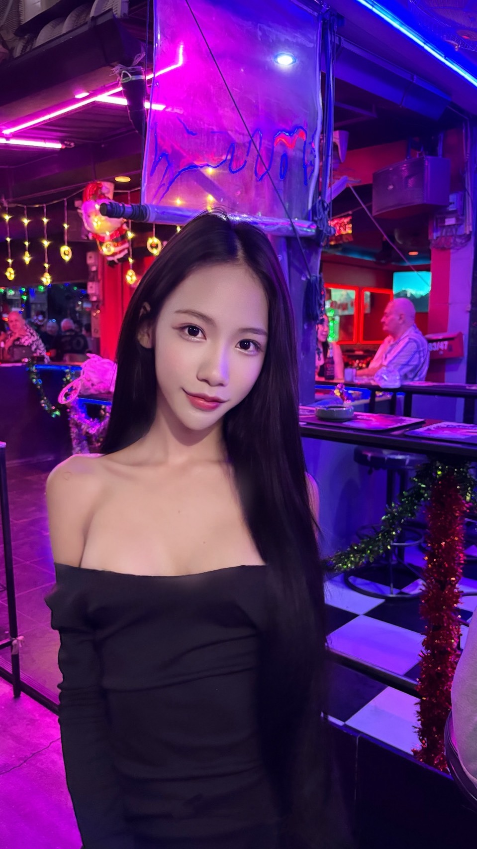 Ladyboy therapist wearing a black dress standing in a bar