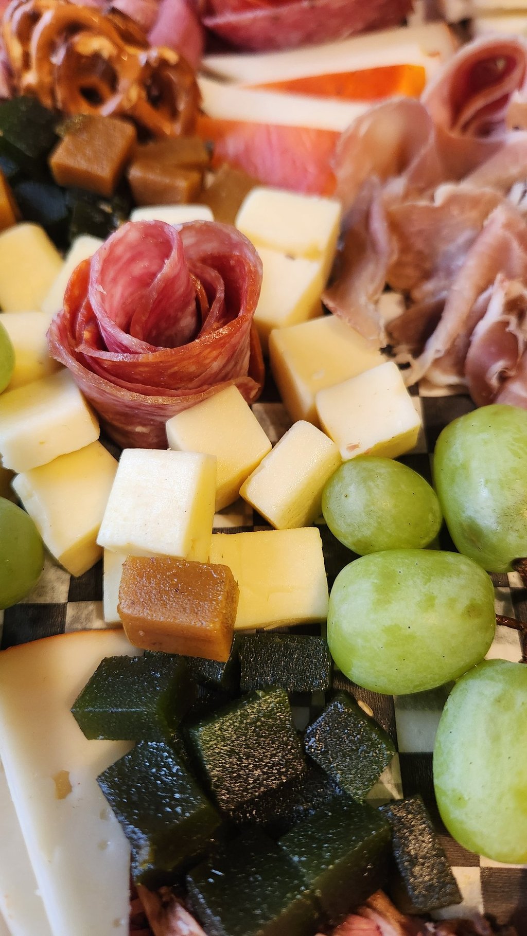 a plate of cheese and grapes on a plate