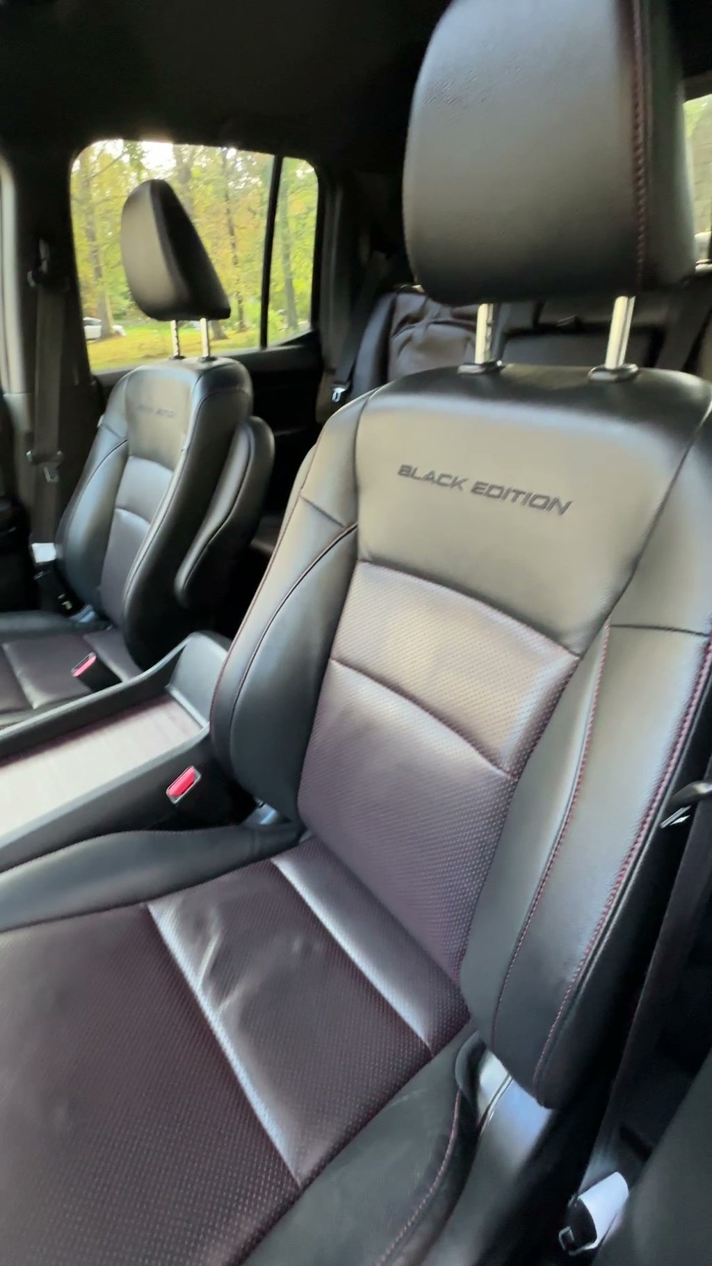 interior mobile detailing of leather seats inside a special black edition truck