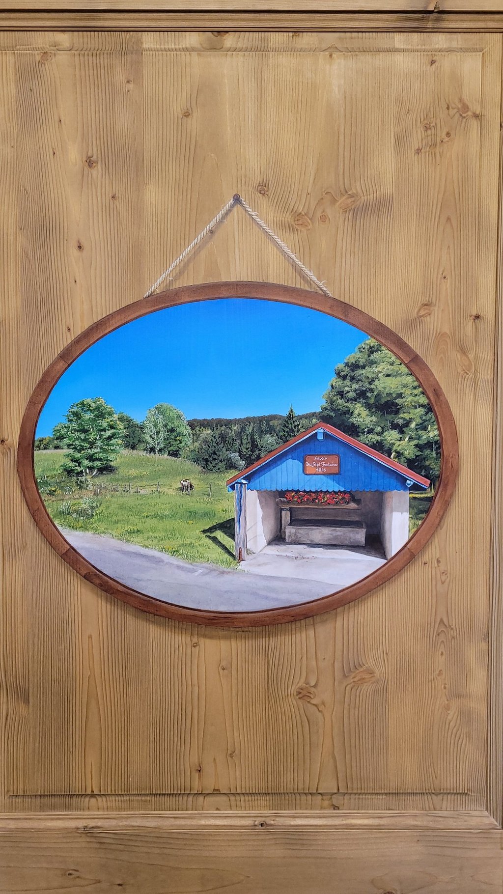 Paysage en médaillon, cadre et fixation sont peints en trompe-l'oeil sur une porte en bois massif