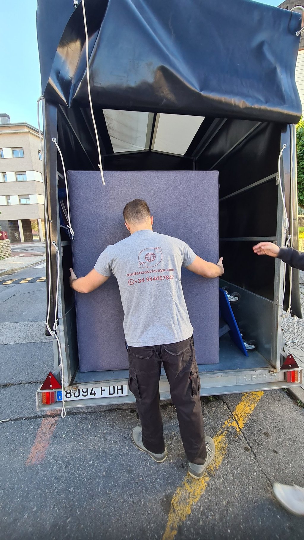 a man is moving a couch into a moving truck