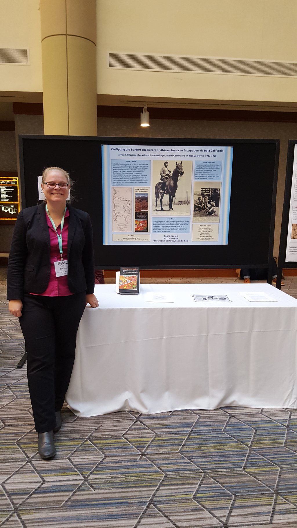 Laura Hooton, left, standing with Little Liberia poster, AHA 2017