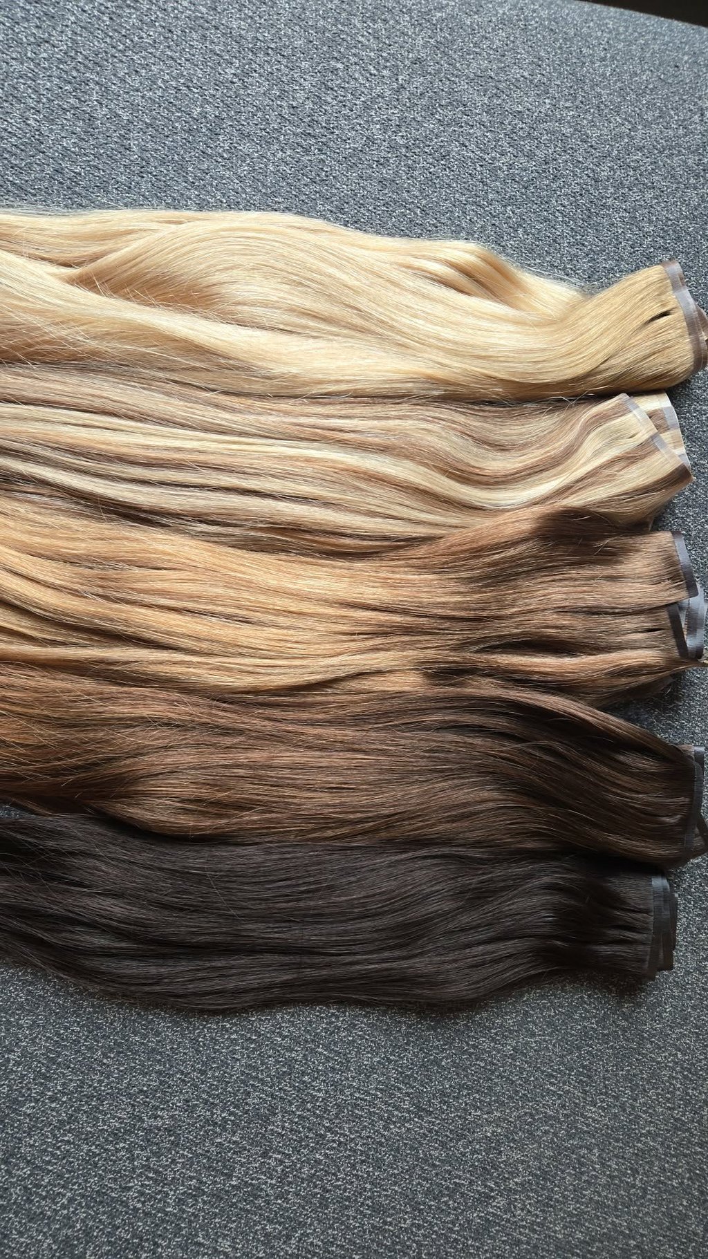 Plusieurs teintes de rallonges capillaires à clips variant du blond au noir.