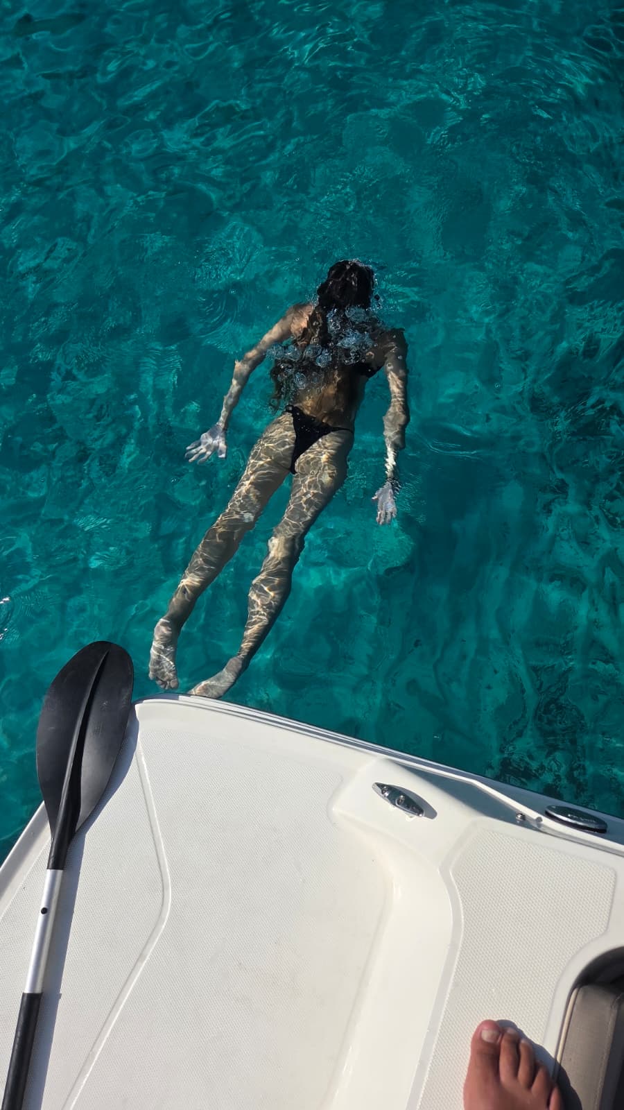 Jeune femme nageant sous l'eau en apnée.