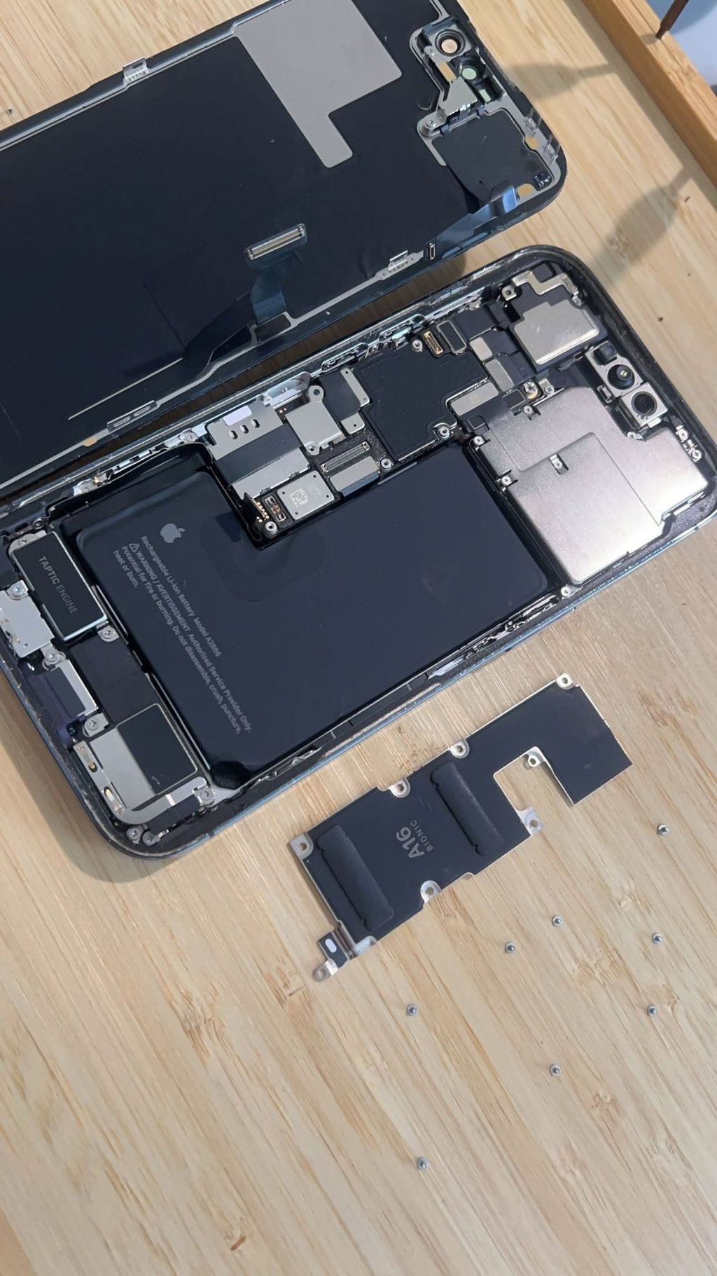 Remplacement de batterie iPhone : intérieur d'un smartphone ouvert en atelier.