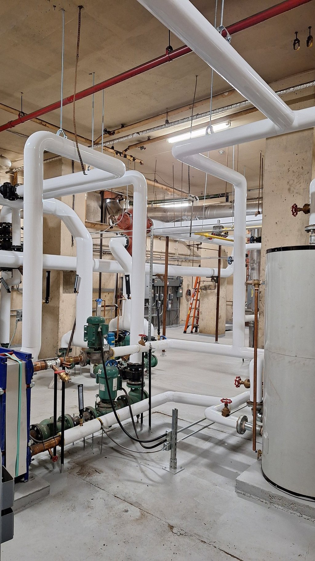 HVAC mechanical room with pumps, and boiler system components.