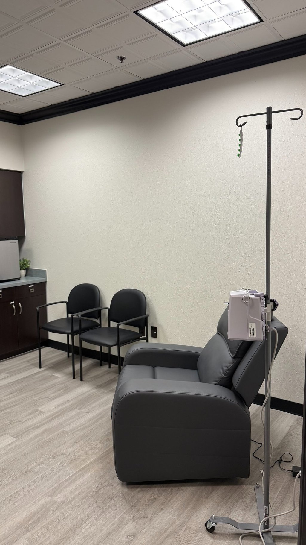 Infusion treatment room with a reclining chair and IV setup for neurological therapies and migraine infusions.