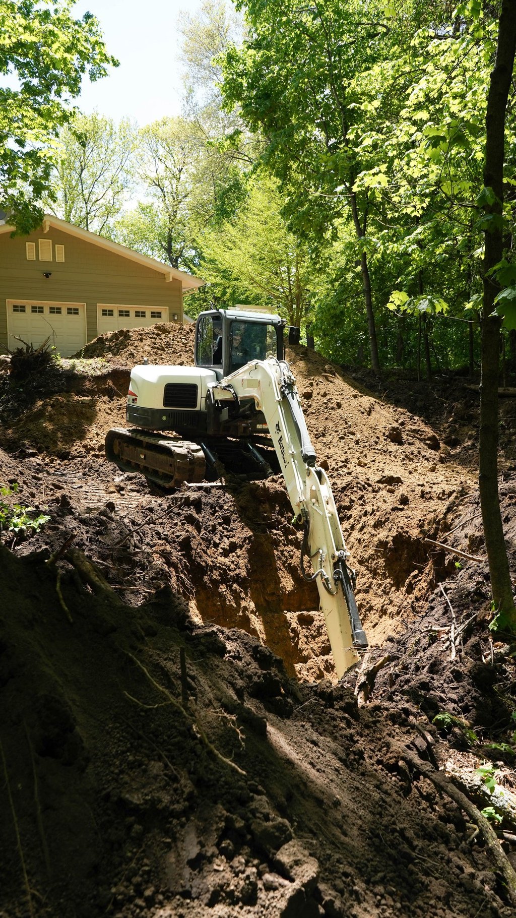 bobcat excavator digging dirt on central mn property