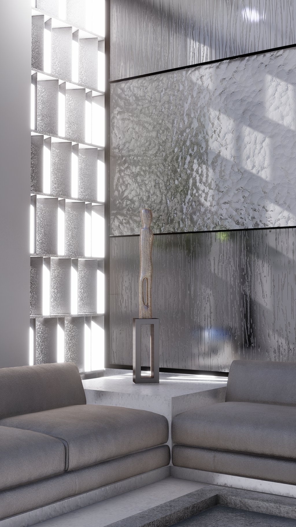 The arrangement of gray sofas and a standing sculpture in front of a modern, textured wall.