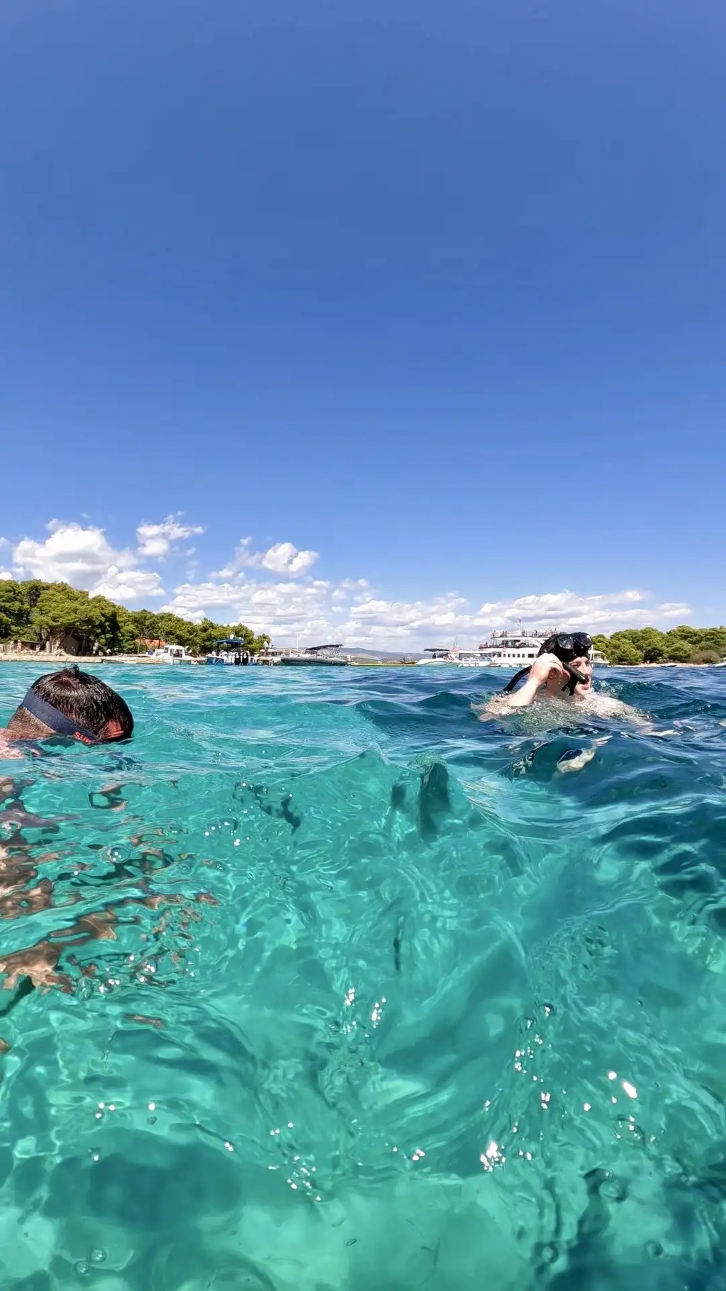 Guests snorkeling and swimming in the turquoise waters of the Blue Lagoon captured at sea level with a GoPro