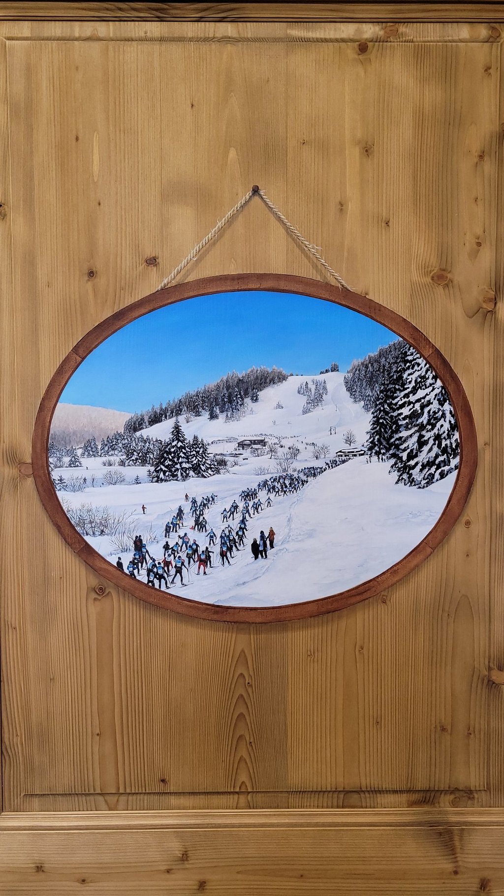 Cadre, ficelle, clou et paysage enneigé du Jura sont peints en trompe-l'oeil sur porte en bois