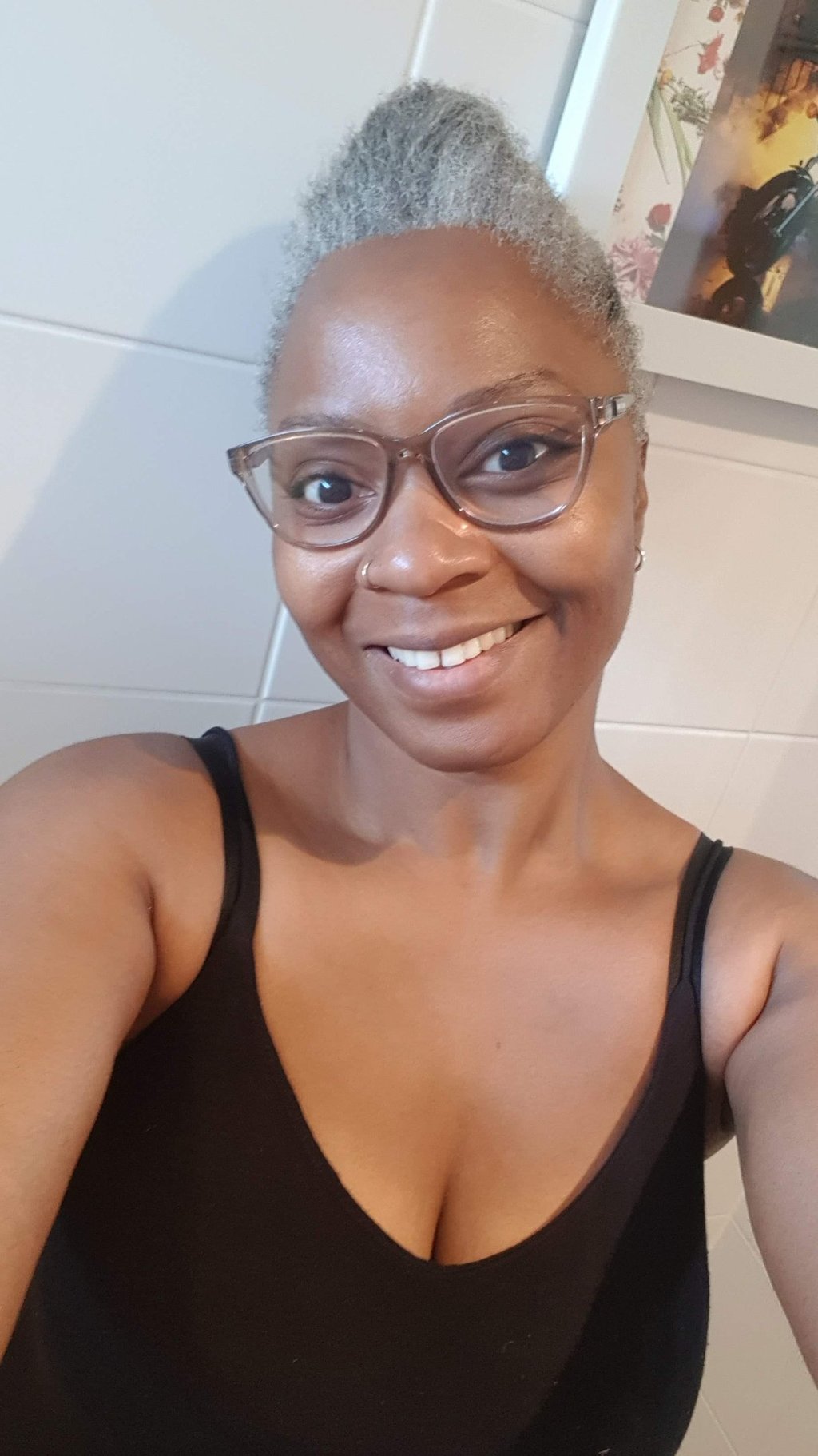 a Black woman with glasses and a black top