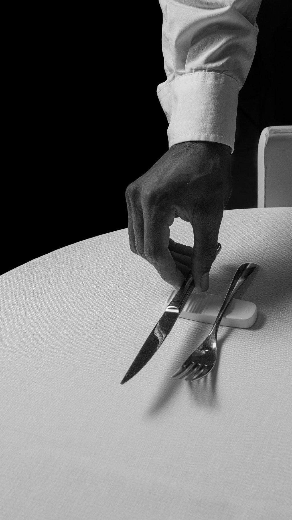 Dettaglio del servizio in sala con cameriere che apparecchia la tavola - Elegant table setting and p