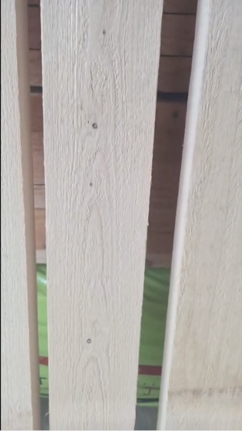 Close-up of light unfinished todomatsu wood boards showing natural grain texture and vertical slats.