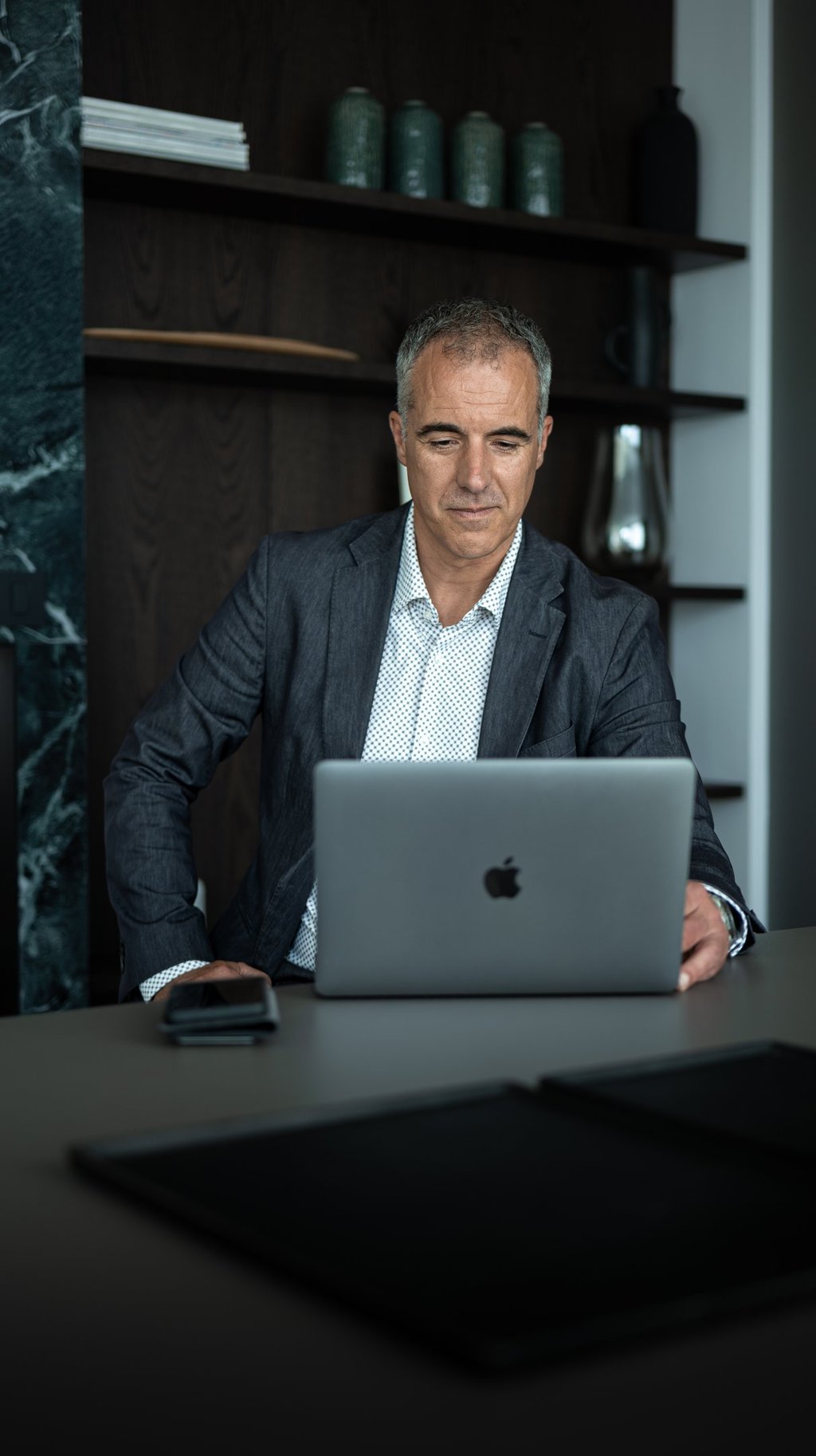 a man in a suit and tie is sitting at a desk