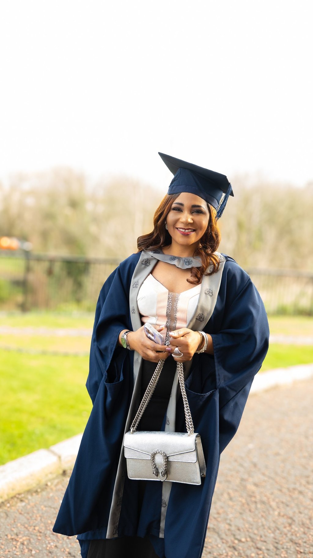 Smiling Black woman in a graduation cap and gown graduation photography Liverpool