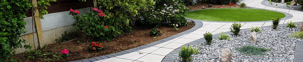 Patio with custom stone circle with aggregates and paving weaving through adventurous garden design