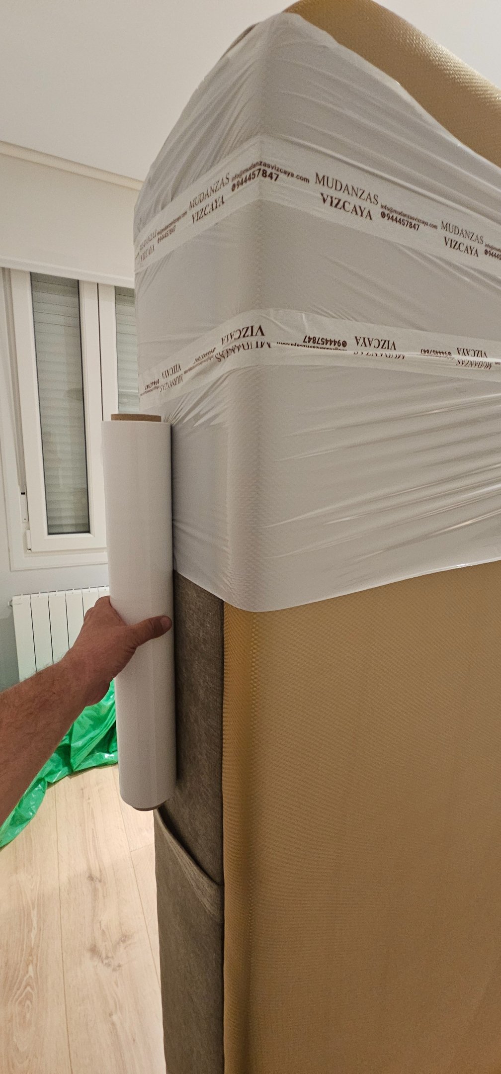 a person holding a box spring mattress on a bed