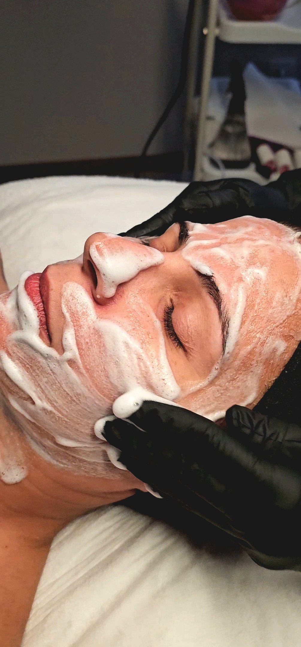detalhe do rosto de uma mulher recebendo tratamento facial de limpeza de pele
