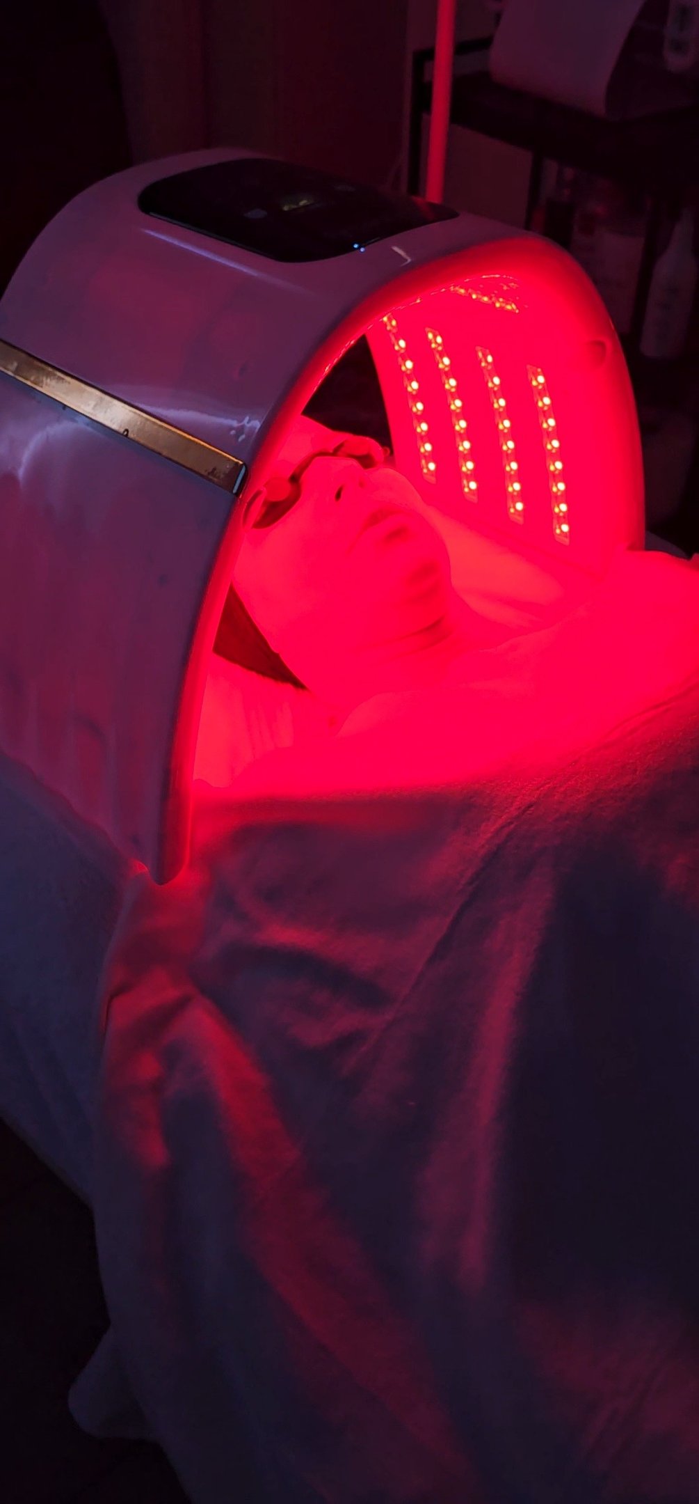 detalhe de uma mulher deitada em uma marquesa recebendo tratamento facial de LED Terapia