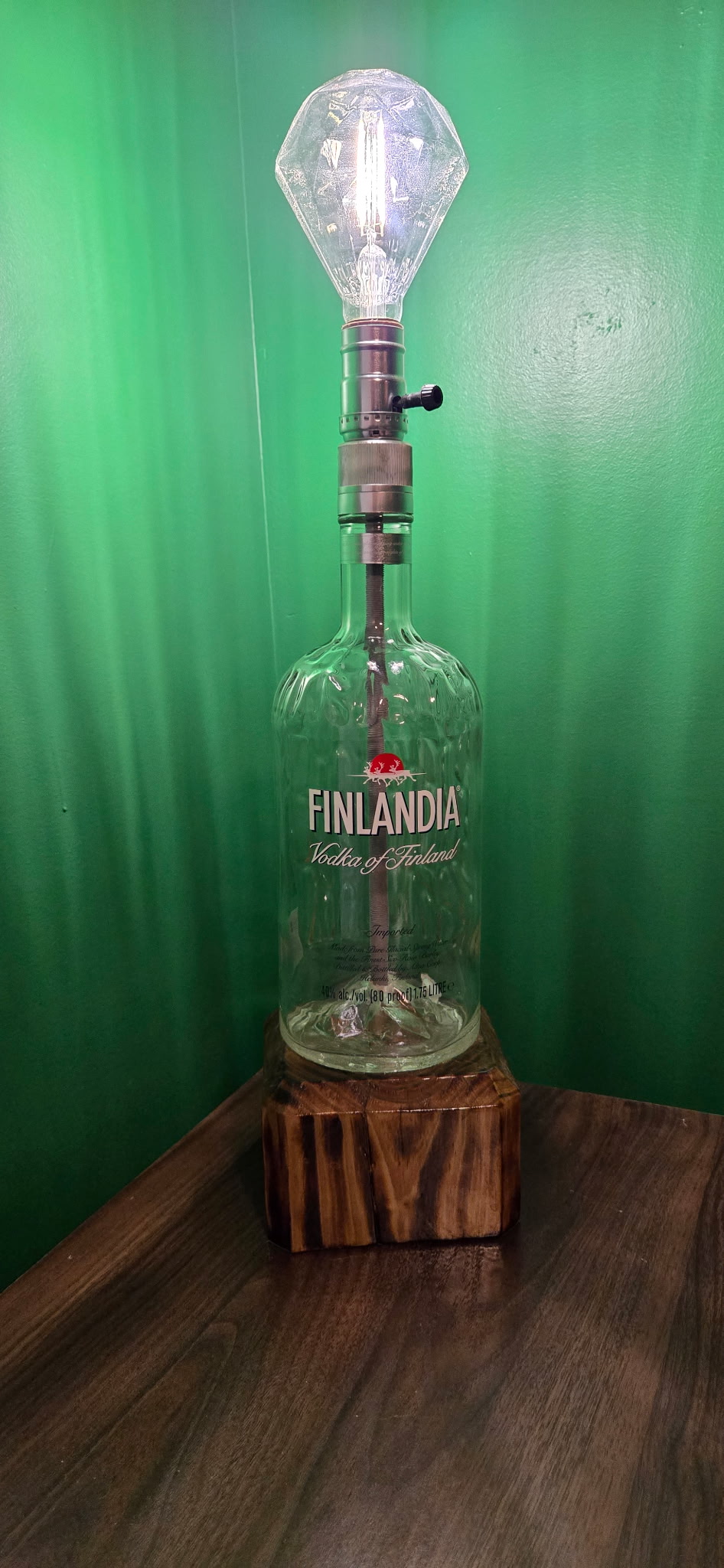 Custom industrial table lamp made from a Finlandia Vodka bottle on a rustic wood base.