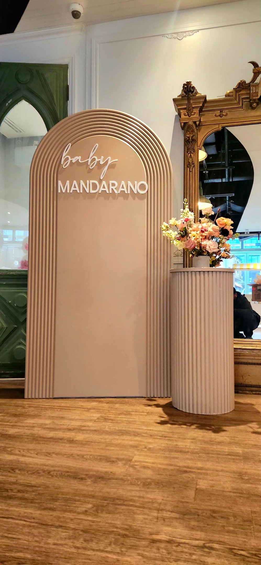 Baby shower with a sign that says, baby mandarino, and a vase with flowers in it