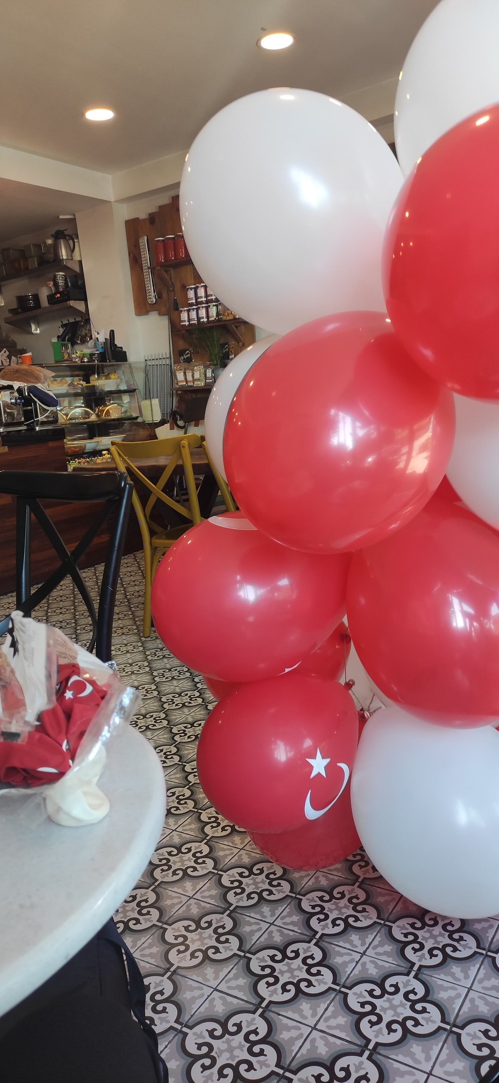 arkada 2 masa ve tezgah görünen balonlarla süslenmiş bir mekan