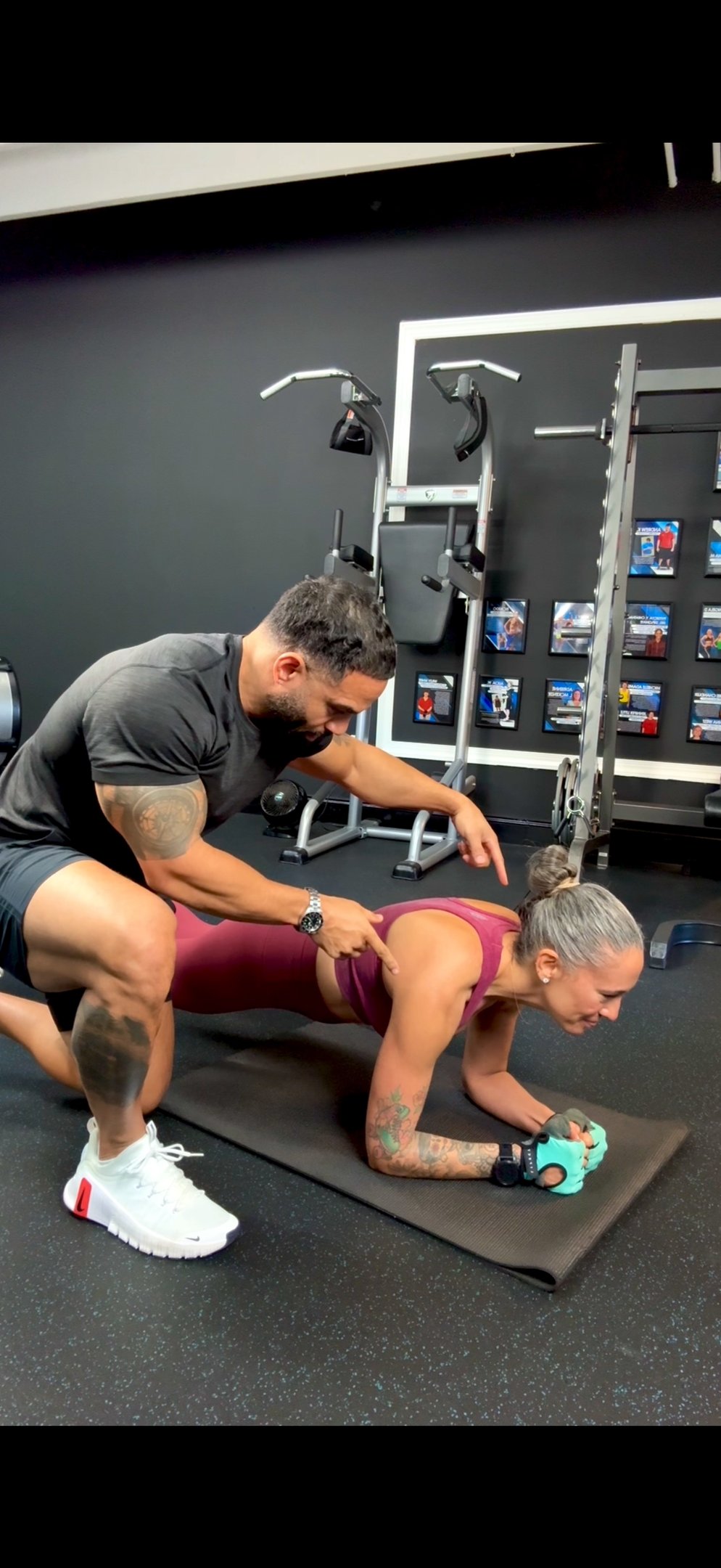 lady getting help with exercise form from persona trainer