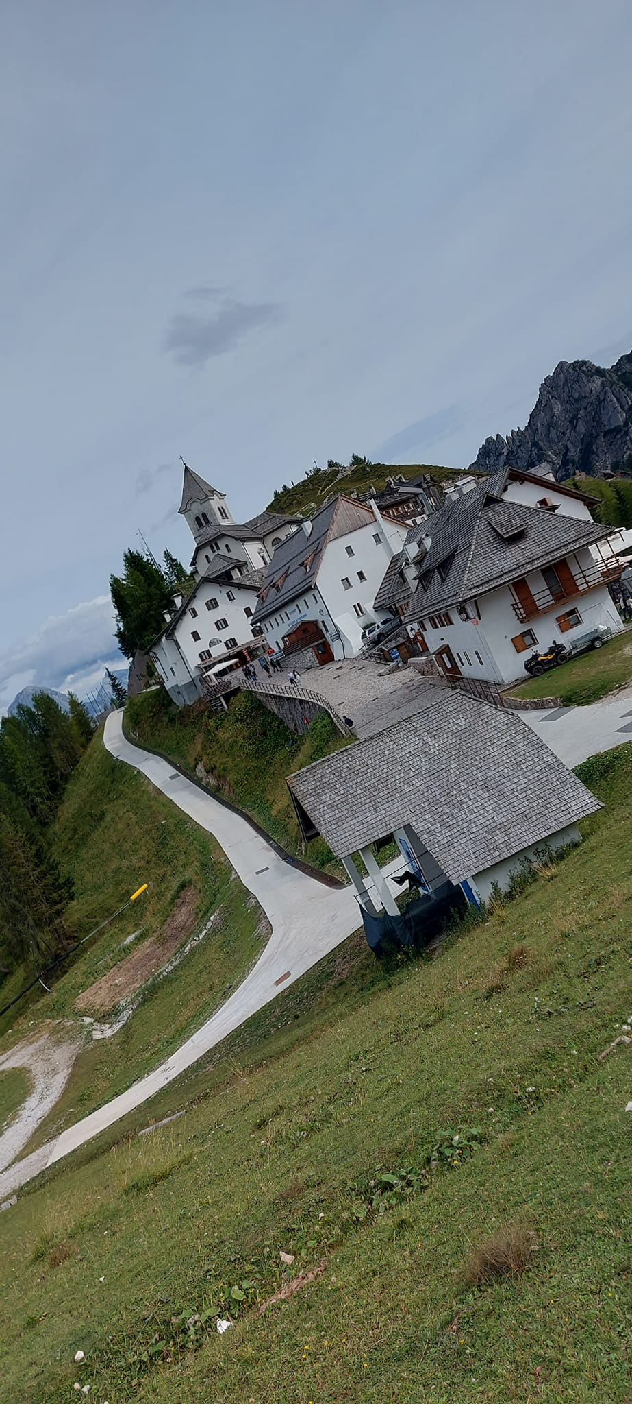 Charming alpine village of Monte Lussari in the Julian Alps with traditional white buildings and a church.