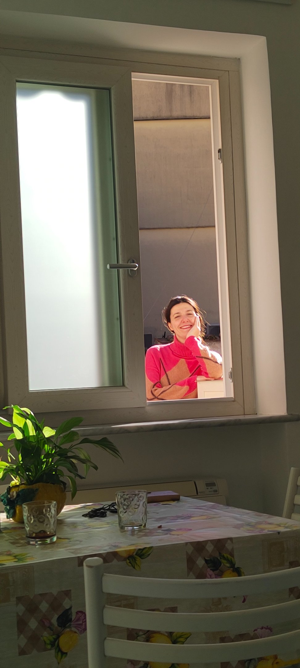 Giusy sorride dalla finestra della nuova casa ad Amalfi, nei primi giorni