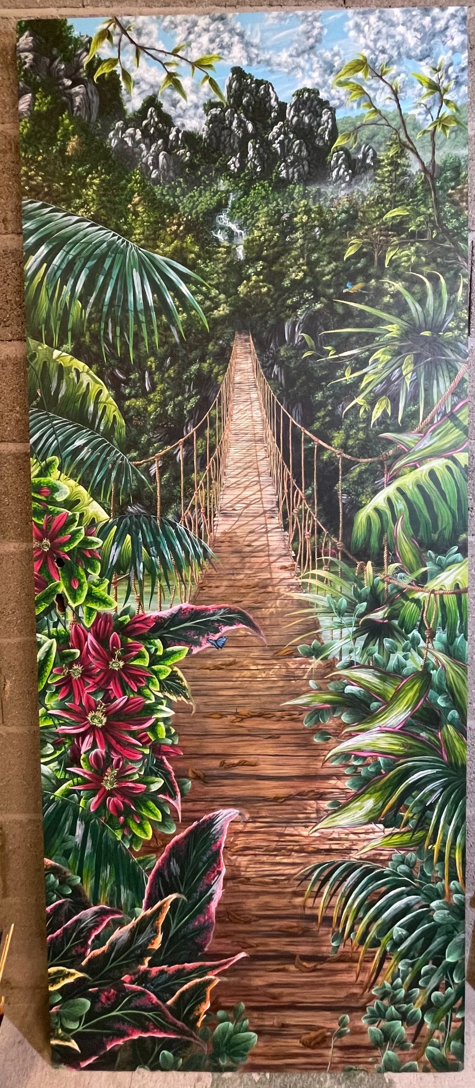 peinture sur une porte d'une foret tropicale avec un pont suspendu