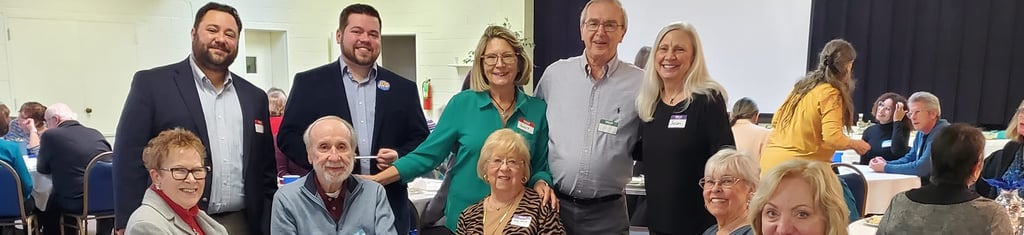 Smiling neighbors gathered around a table at a fundraising event