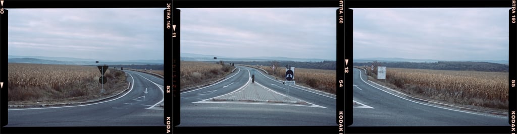Composite color photograph of a winding road with traffic signs amidst fields, captured on KODAK PROFESSIONAL film