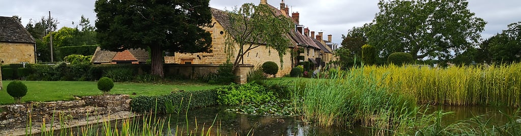 a photo of Willersey village pond with cottages in the background