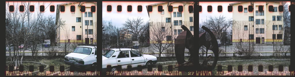 Composed photo portraying a city street with parked cars and buildings, presented in a film strip format.
