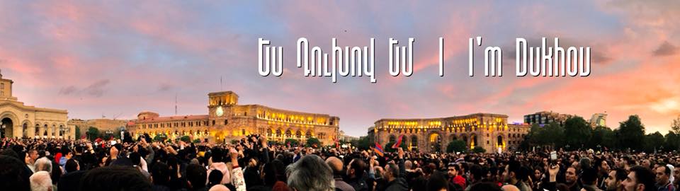 Crowd gathering in Republic Square Yerevan during the Velvet Revolution at sunset with I'm Dukhou text.
