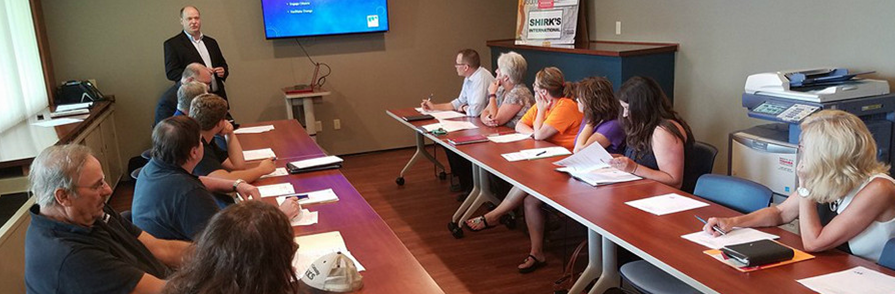 a man in a suit and tie is standing in front of a group of people