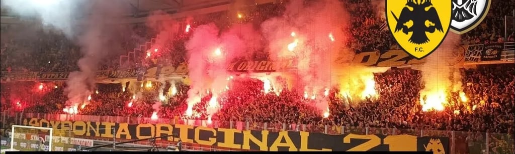 AEK Athen Fan im Stadion jubelt leidenschaftlich während eines Spiels, Fahnen wehend, Gesänge schallend, in voller Fan-Ausrüs