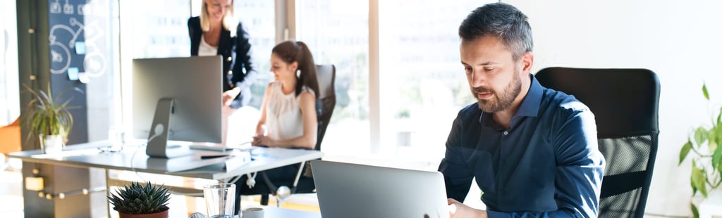 a man sitting at a desk with a laptop computer
