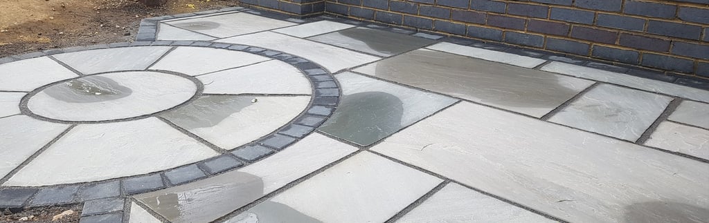 Blue Perforated Brick Wall Planter With Grey Sandstone Circle & Patio Paving & Wooden Pergola